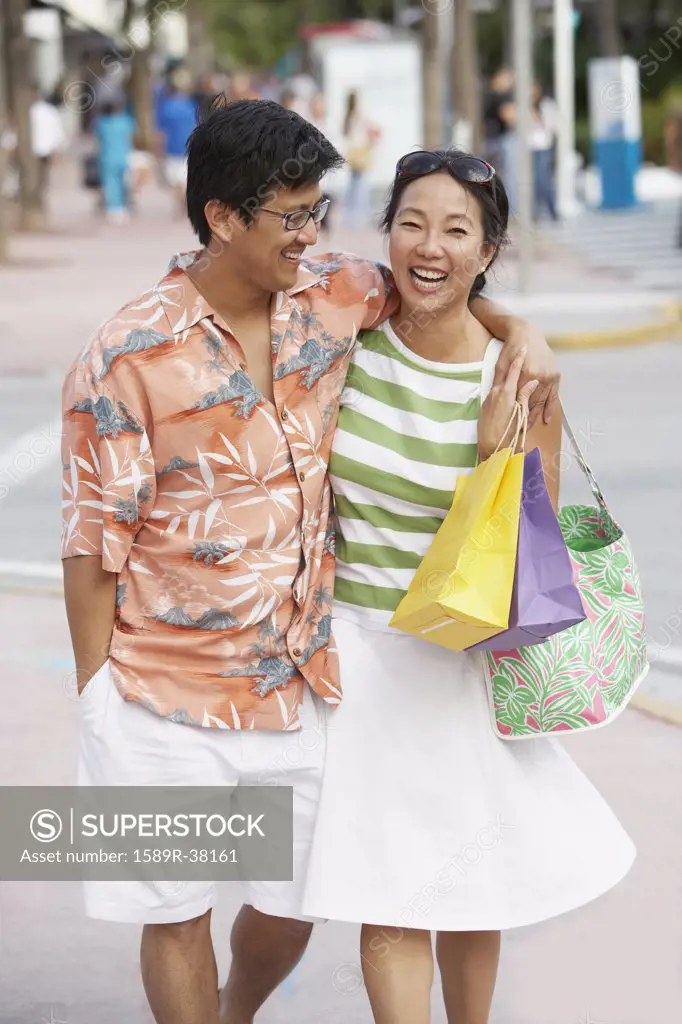 Asian couple walking on sidewalk