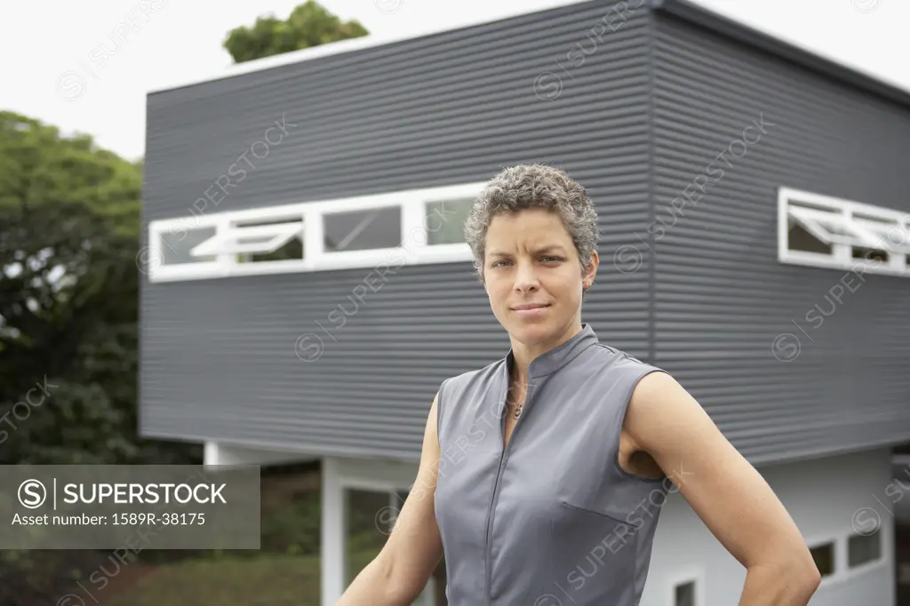 Mixed Race woman standing in front of house