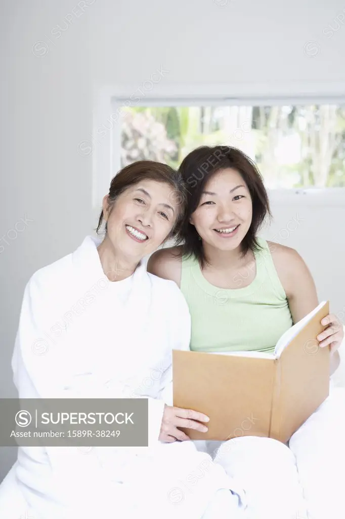 Asian mother and adult daughter looking at photo album