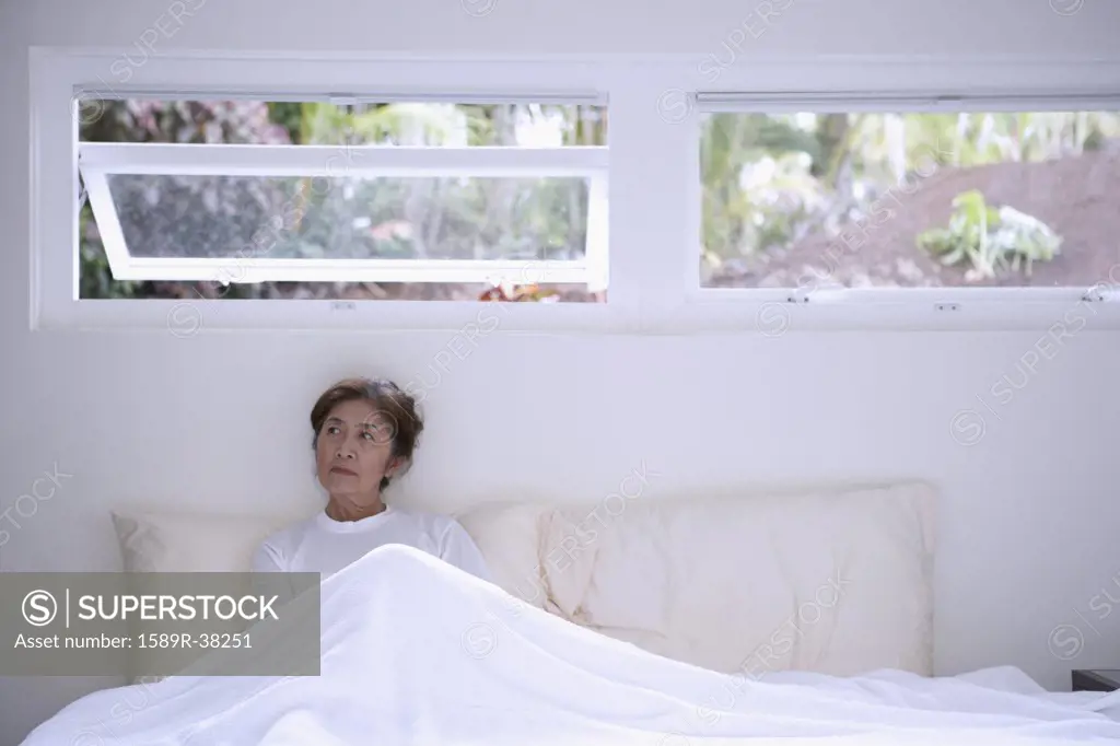 Senior Asian woman sitting in bed