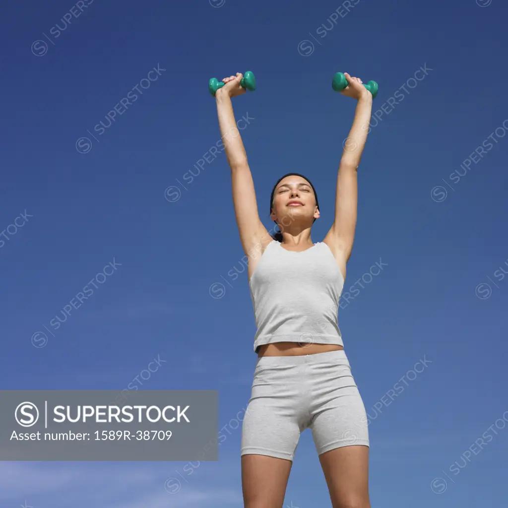 Mixed Race woman lifting weights