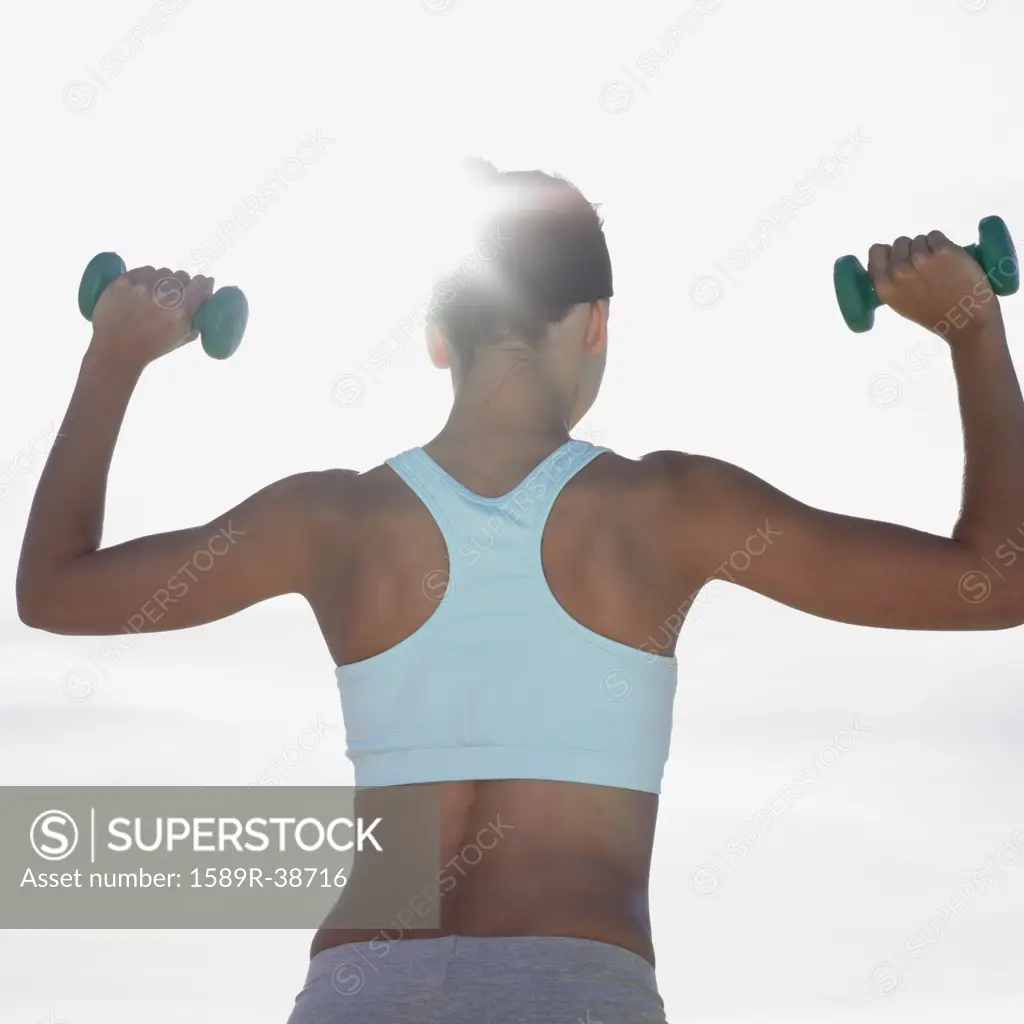 Mixed Race woman lifting weights