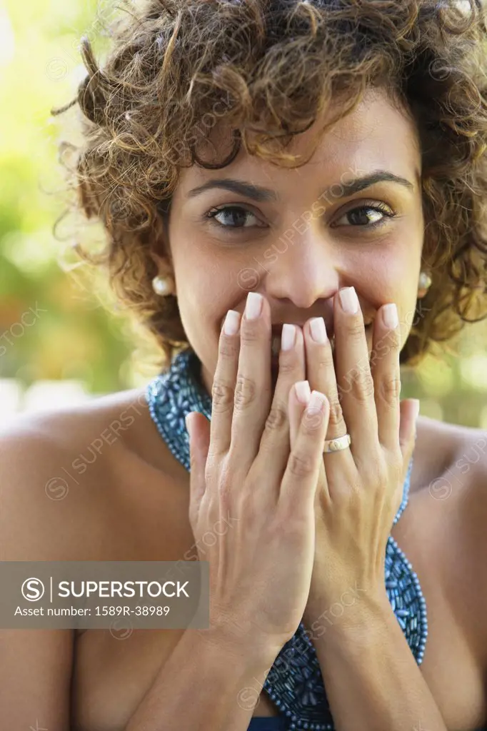 South American woman covering mouth