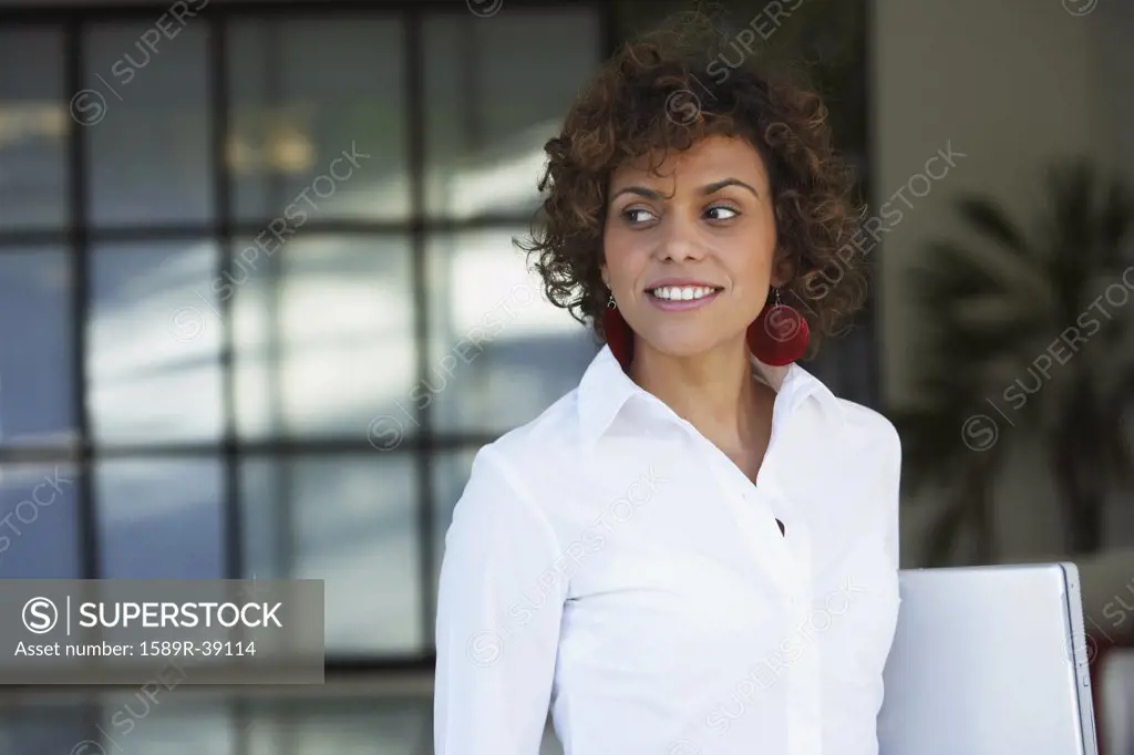 South American businesswoman holding laptop