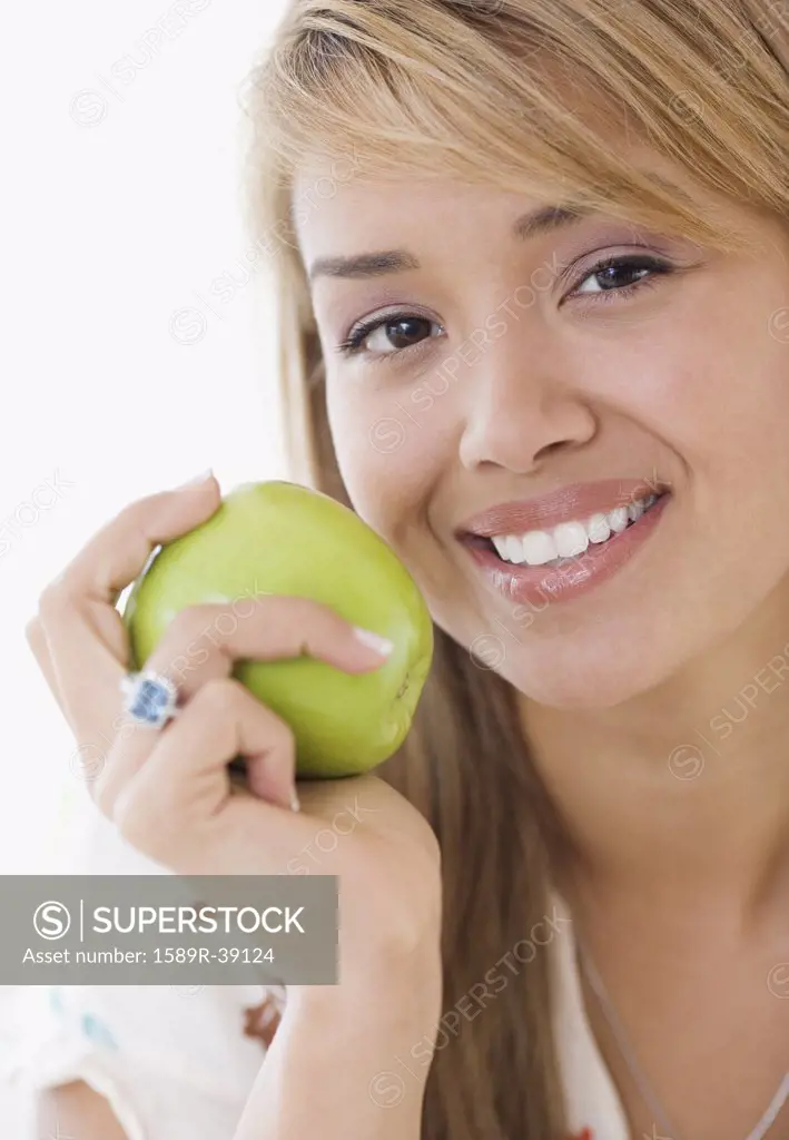 Hispanic woman eating apple