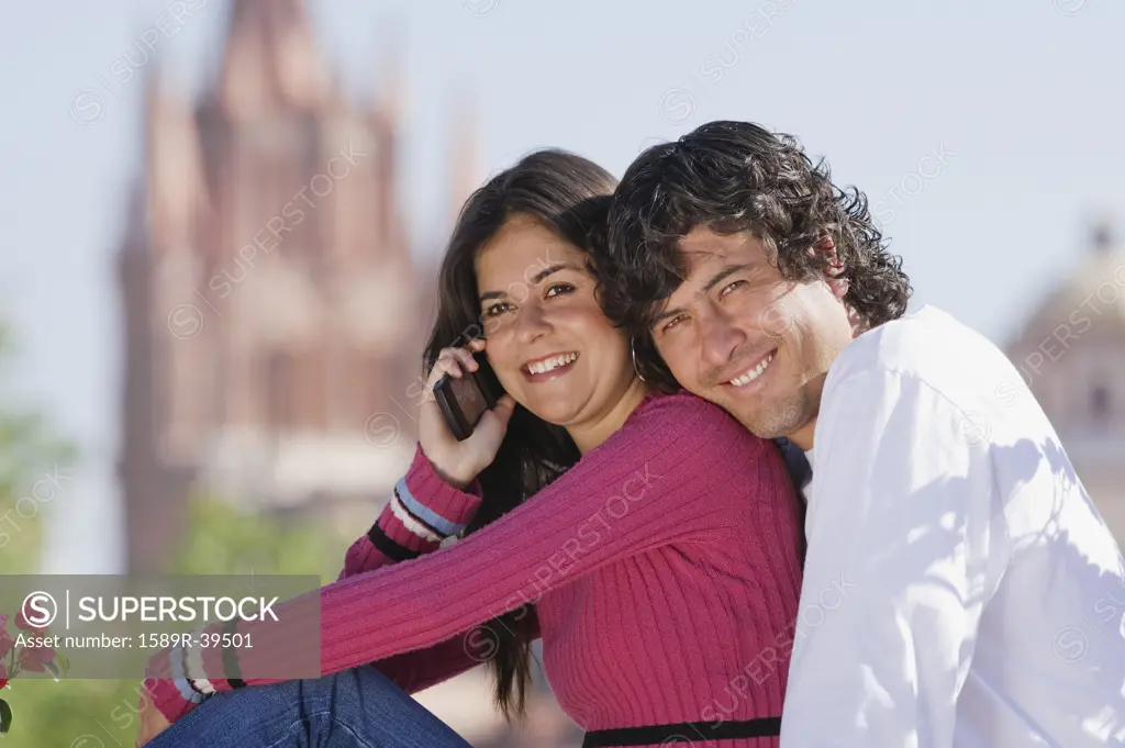 Hispanic couple talking on cell phone