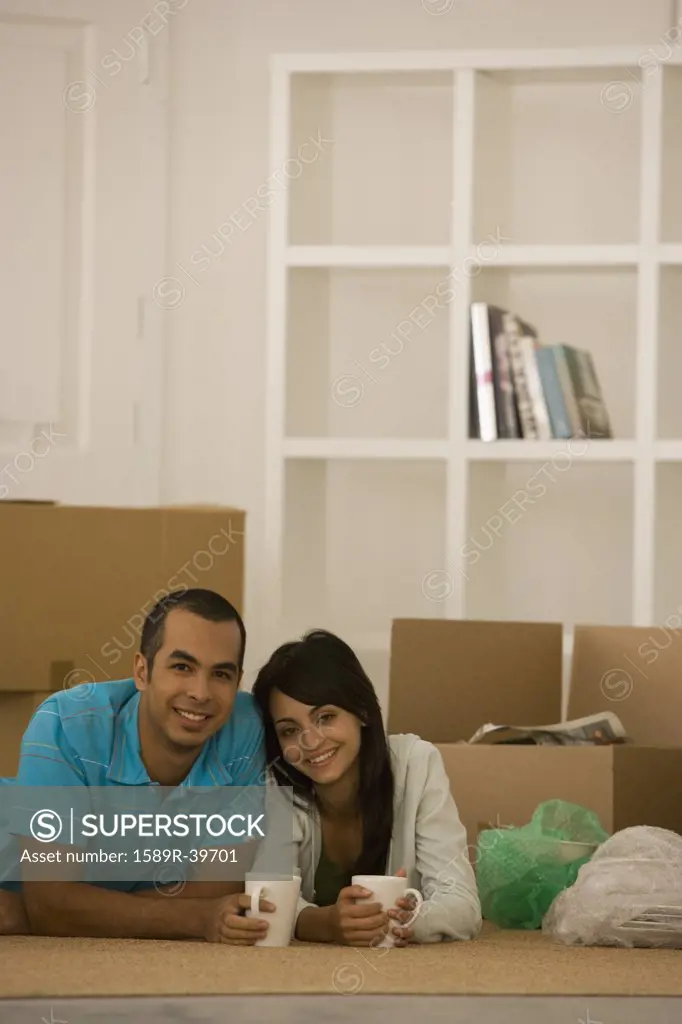 Young couple next to unpacked moving boxes