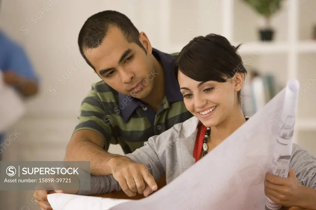 Young couple looking at blueprints in new house