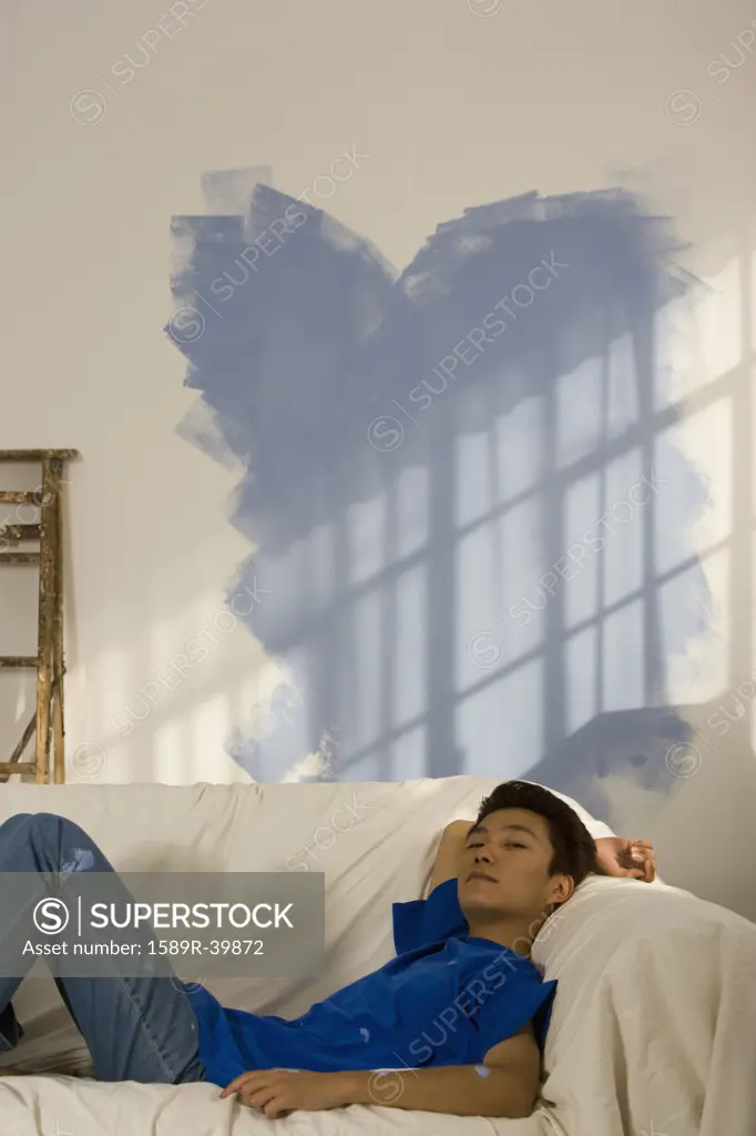 Asian man in partially painted room