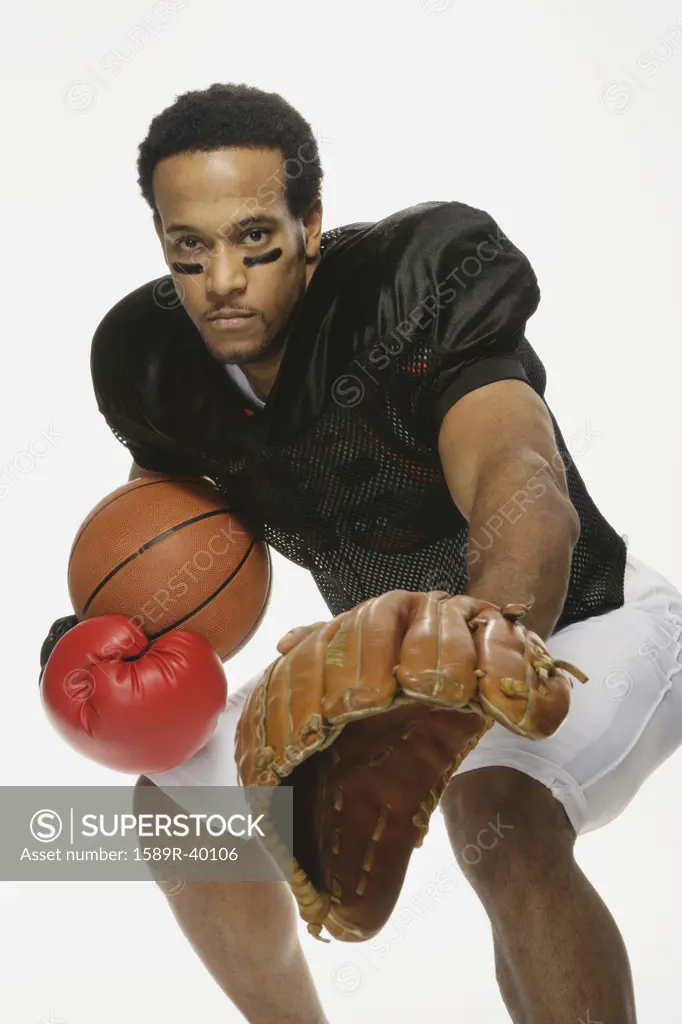 African American man with a variety of sports equipment