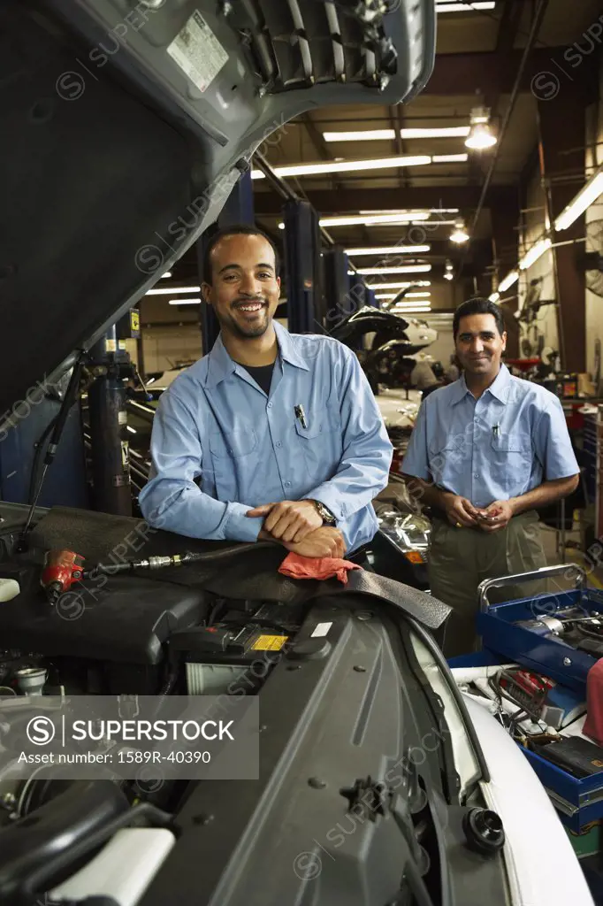 Multi-ethnic male auto mechanics in shop