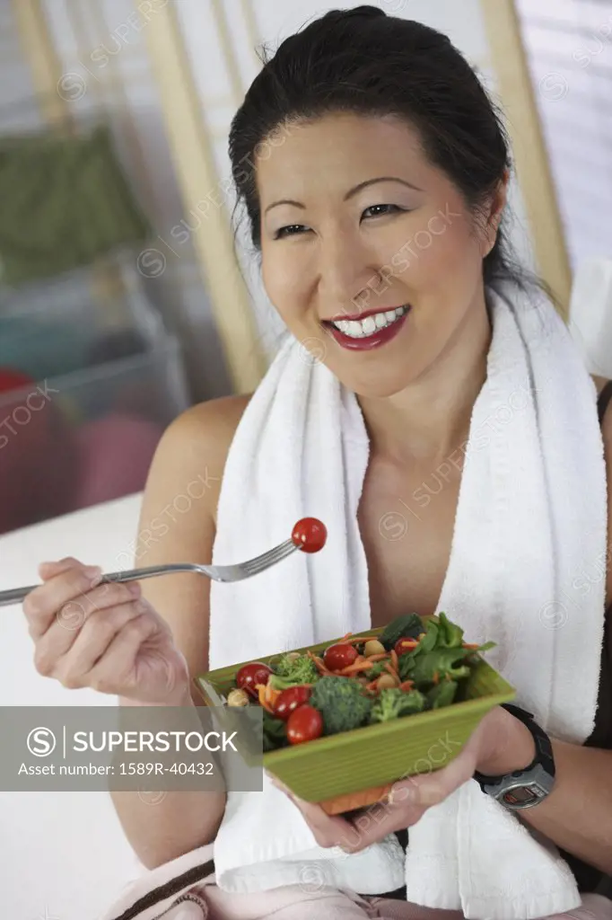 Asian woman eating salad