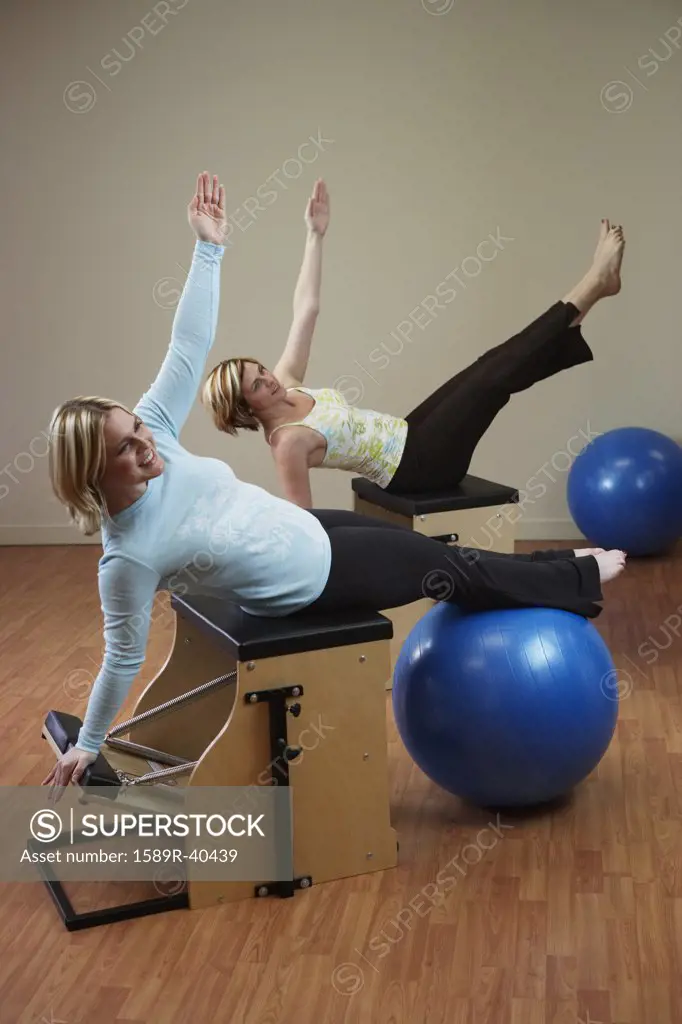Two woman exercising on equipment