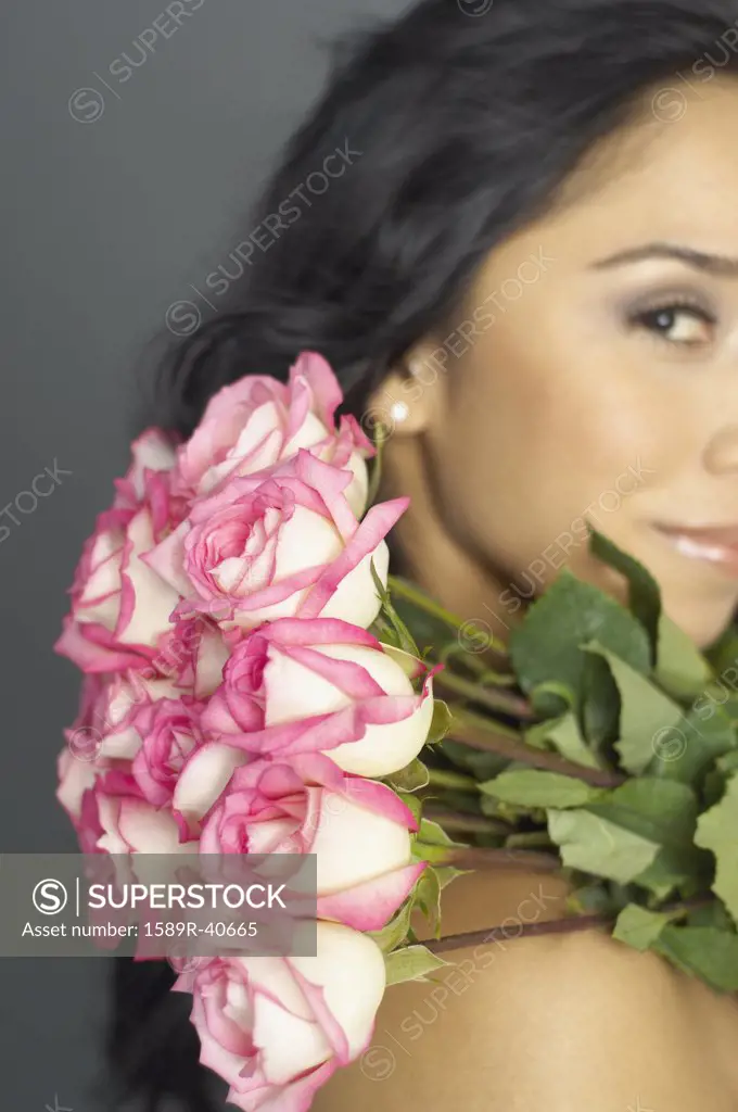 Hispanic woman holding bouquet of flowers