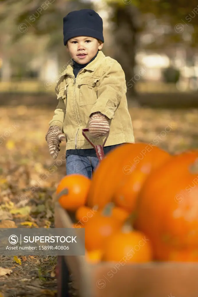 African boy pulling wagon of pumpkins