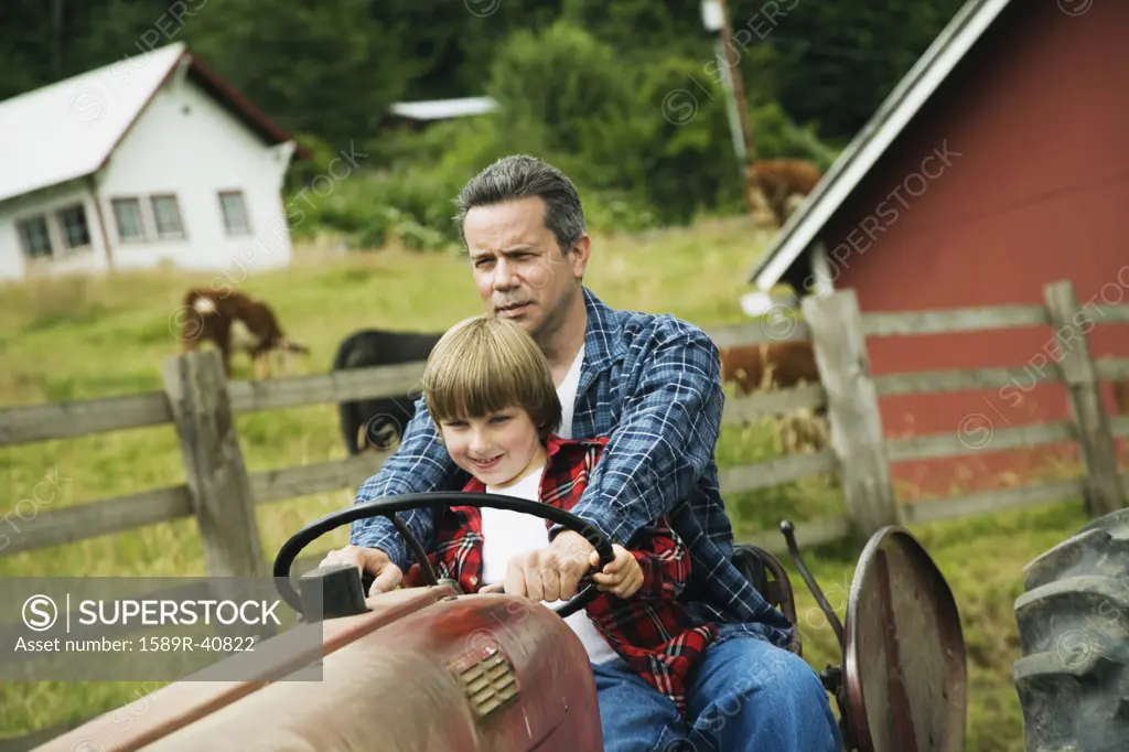 Father and son driving tractor