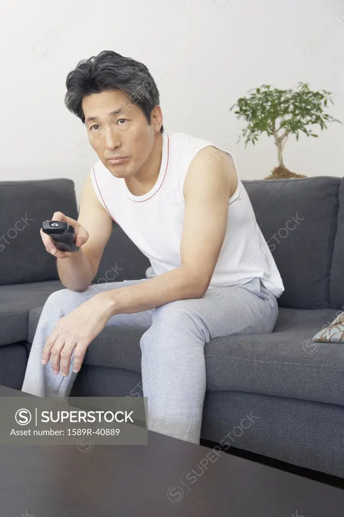Asian man pointing remote control