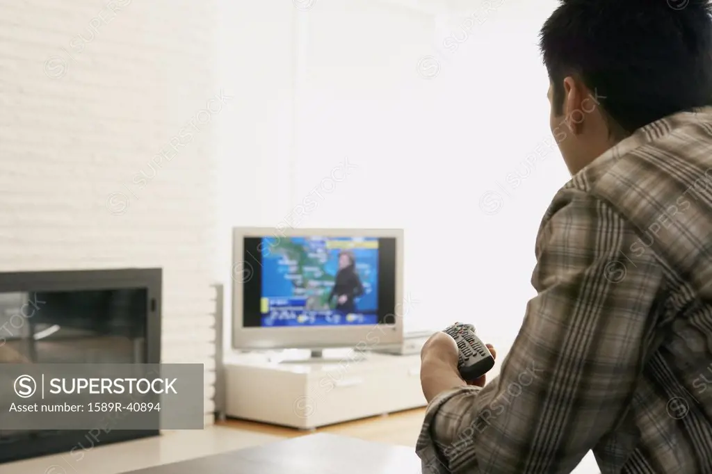 Asian man watching television