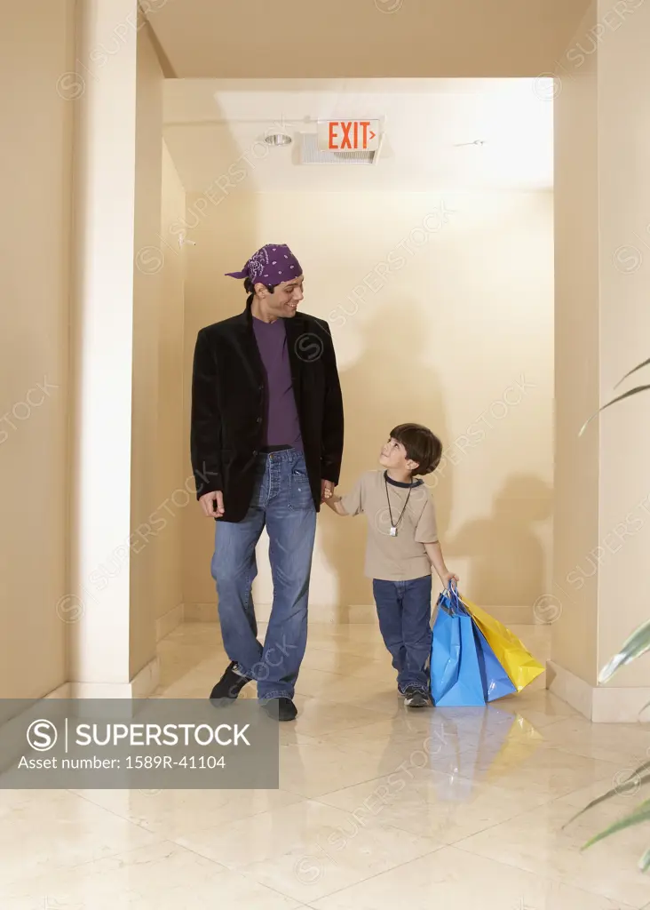 Hispanic father and son carrying shopping bags