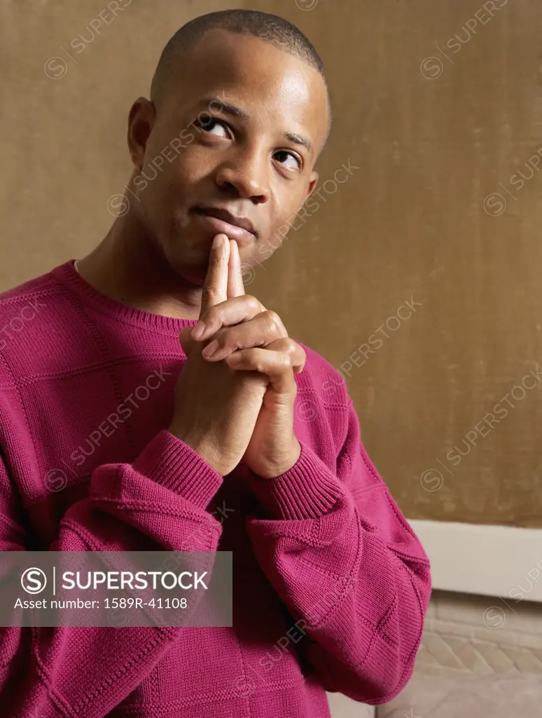 African man touching fingers to chin