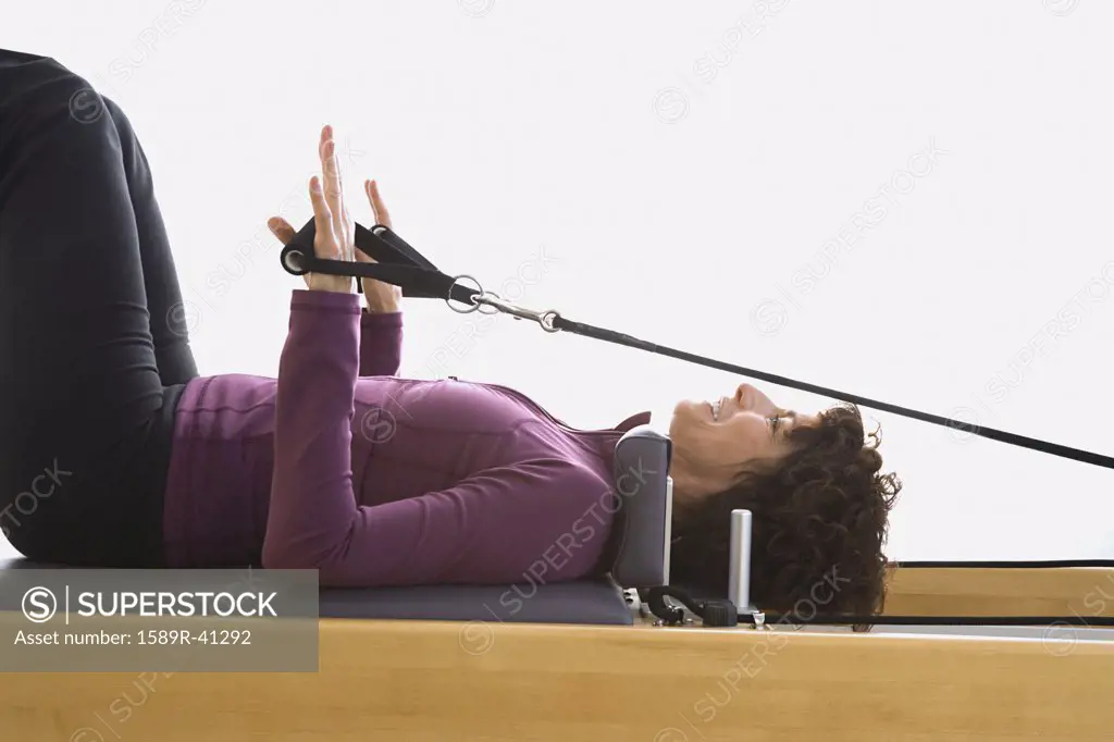 Senior woman stretching on exercise equipment