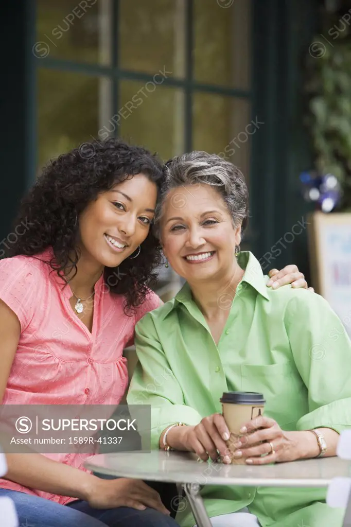 African American mother and adult daughter hugging