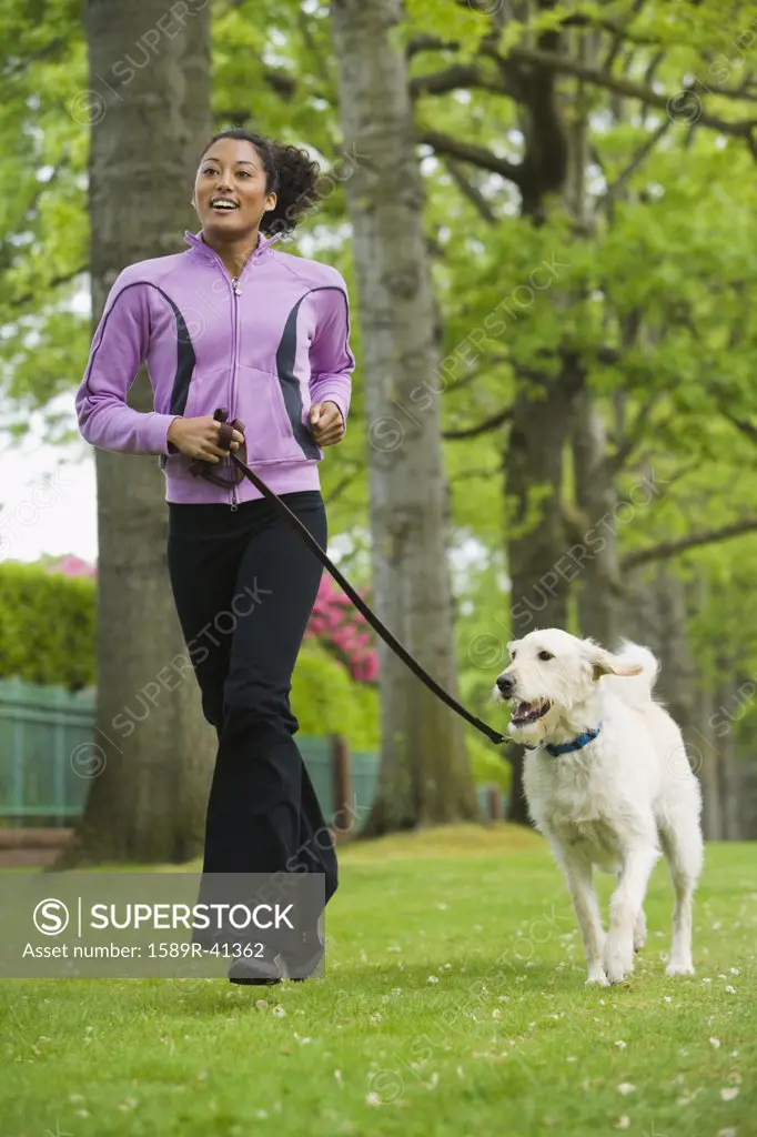 African American woman jogging with dog