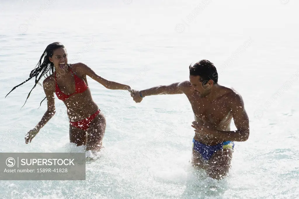 South American couple running in water