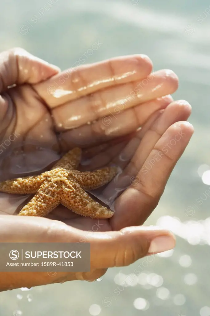 South American woman holding starfish