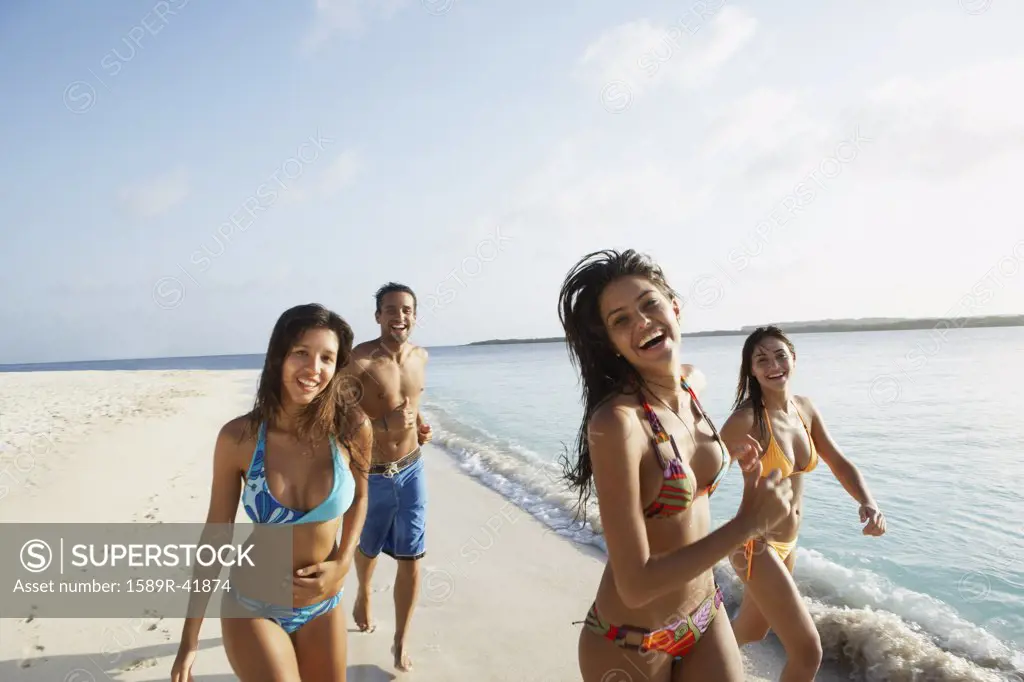 South American friends running at beach