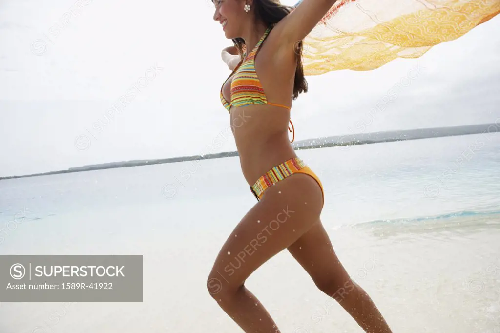 South American woman running on beach