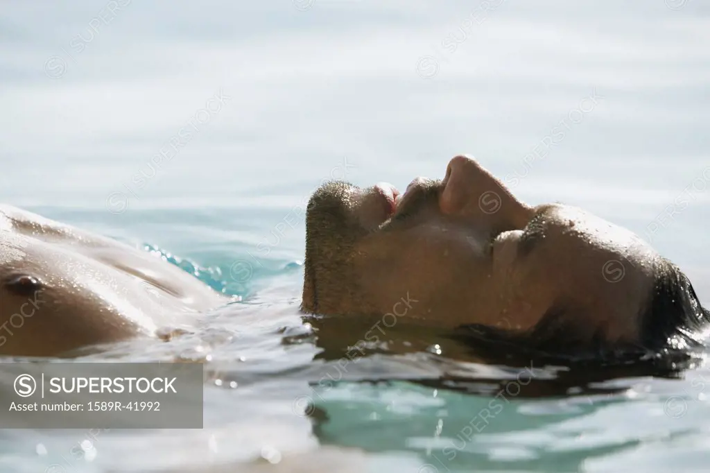 South American man floating in water