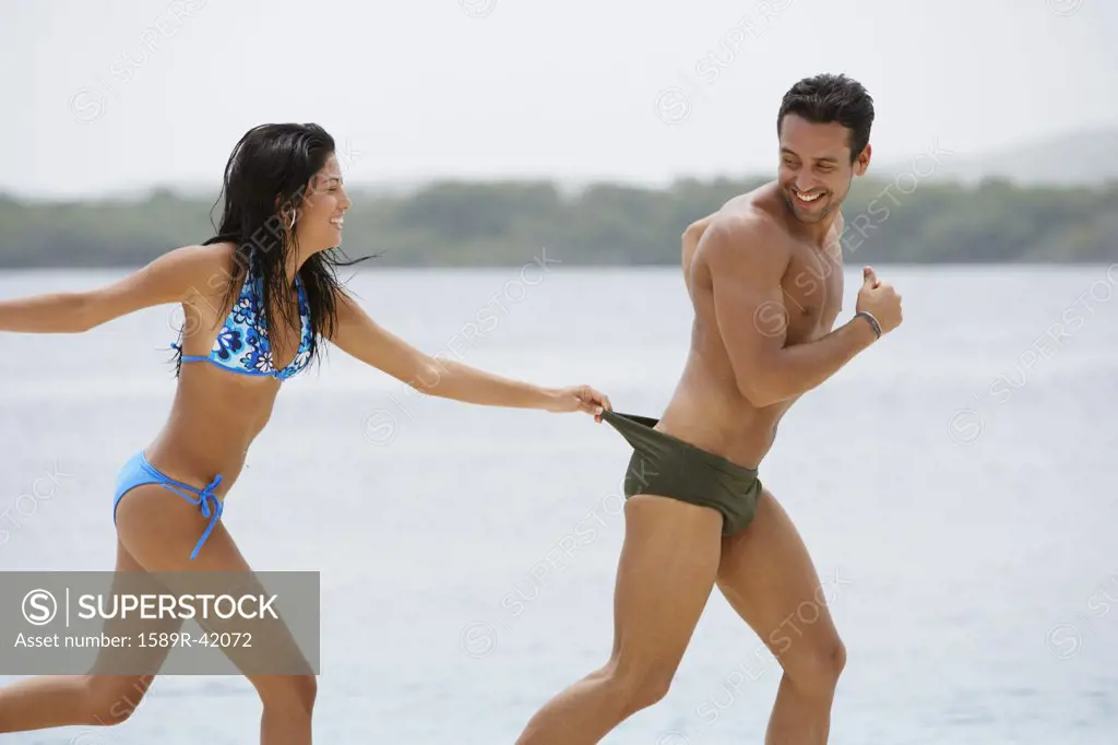South American couple playing at beach
