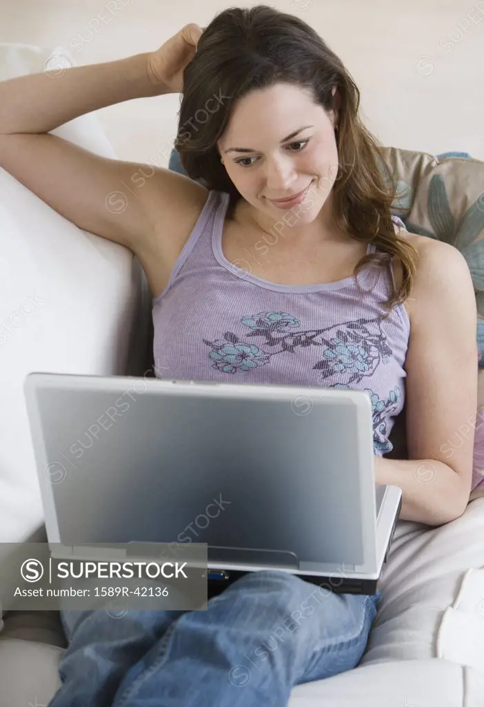 Hispanic woman looking at laptop