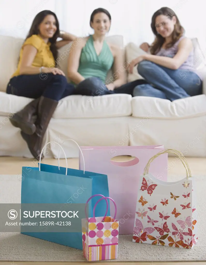 Three young women looking at gift bags