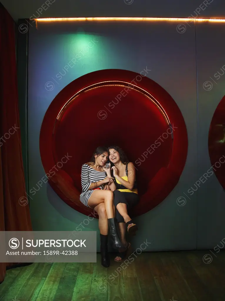 Hispanic women talking on cell phone in nightclub