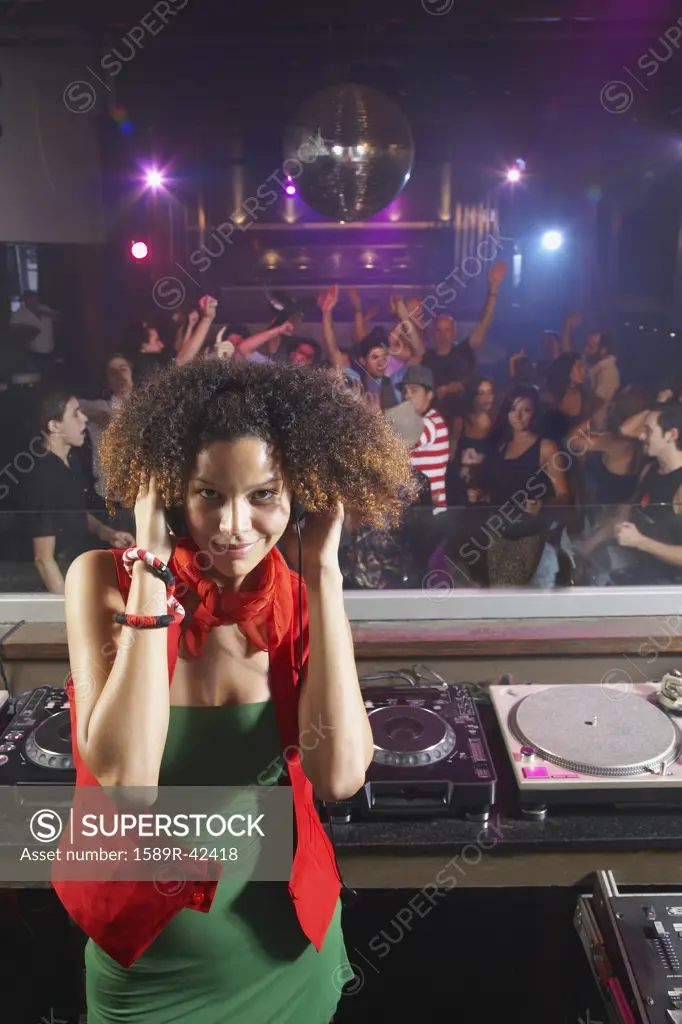 Hispanic woman djing at nightclub