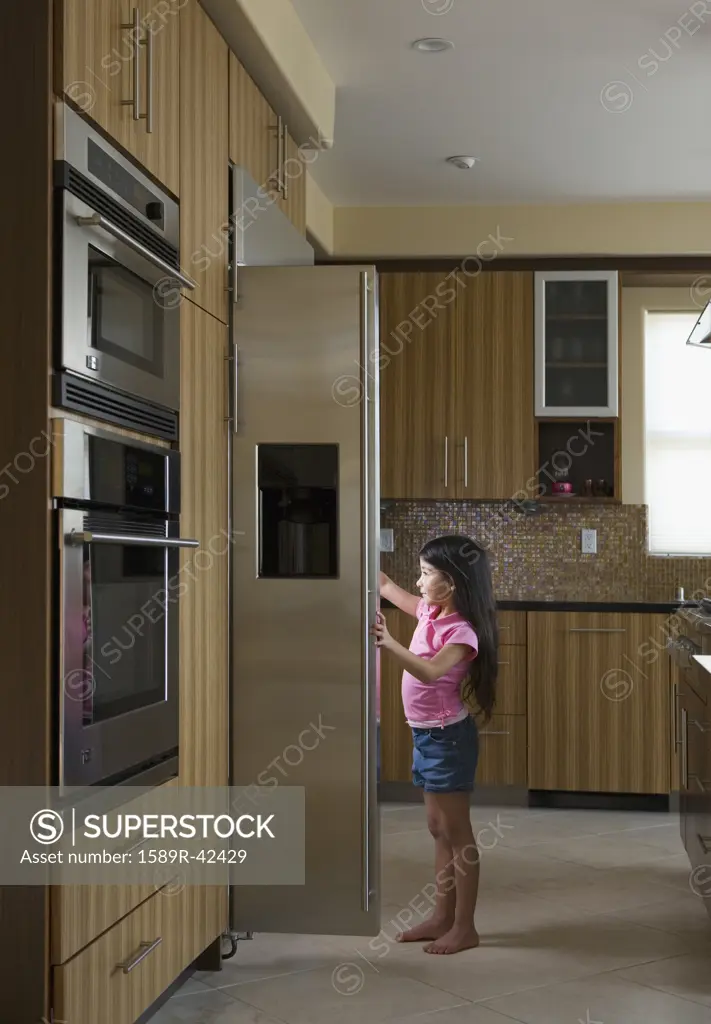 Hispanic girl looking in refrigerator
