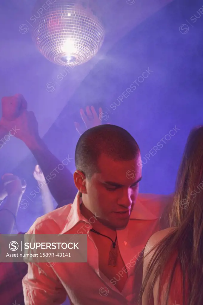 Multi-ethnic couple dancing at nightclub