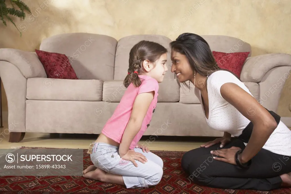 Indian mother and daughter smiling at each other
