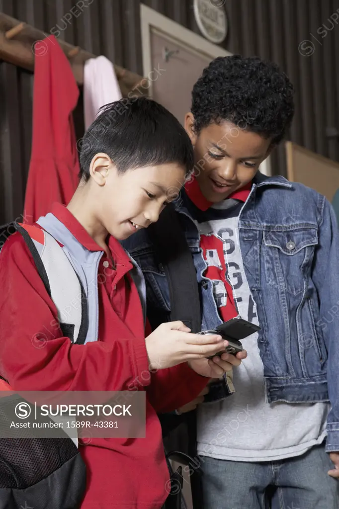 Multi-ethnic school boys looking at cell phone