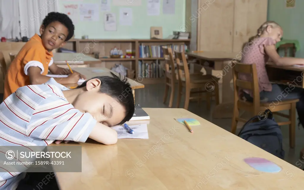 Asian boy sleeping in classroom