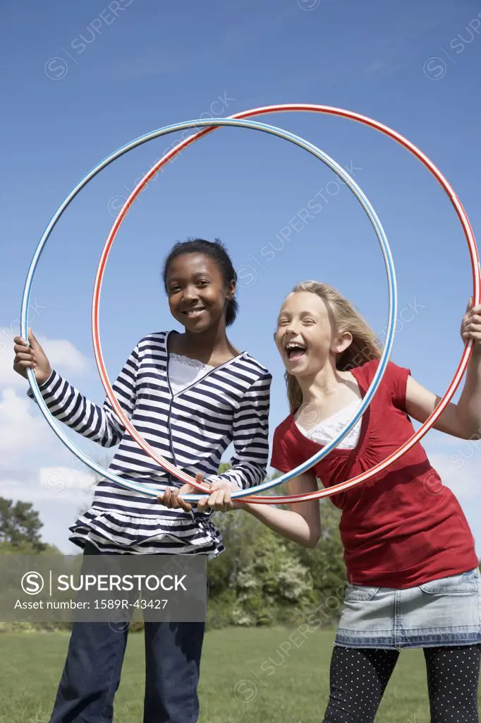 Multi-ethnic girls playing with hula hoops