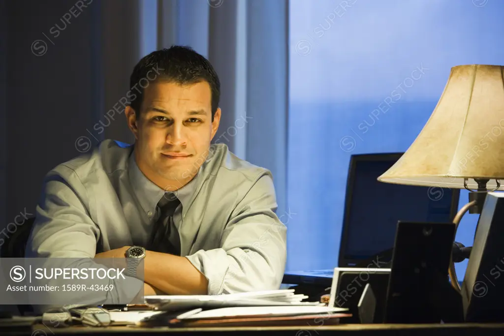 Portrait of Hispanic businessman at desk