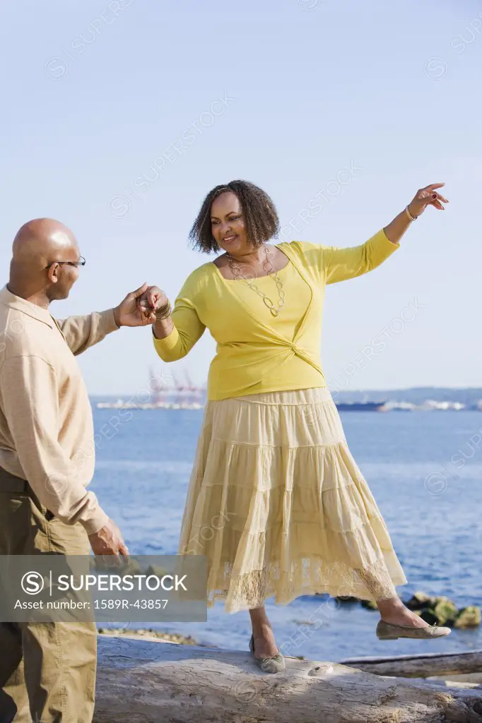 African American woman holding husbands hand for balance