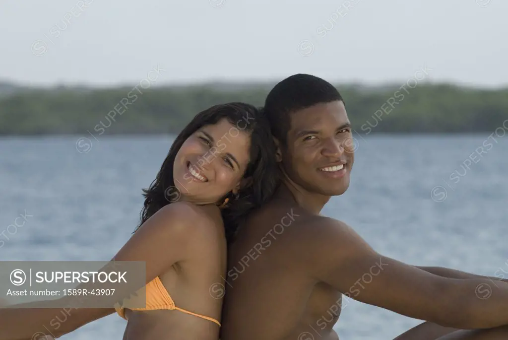 Hispanic couple sitting back to back