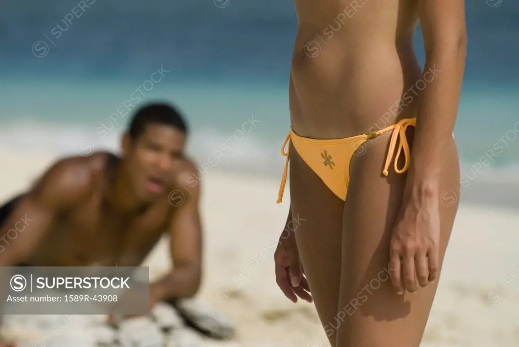 Hispanic man looking at woman on beach