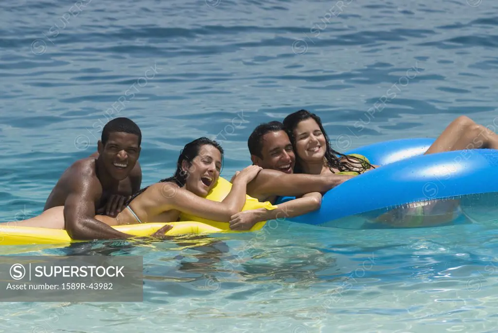 Multi-ethnic friends on floats in water