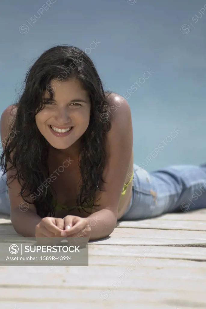 Hispanic woman laying on dock