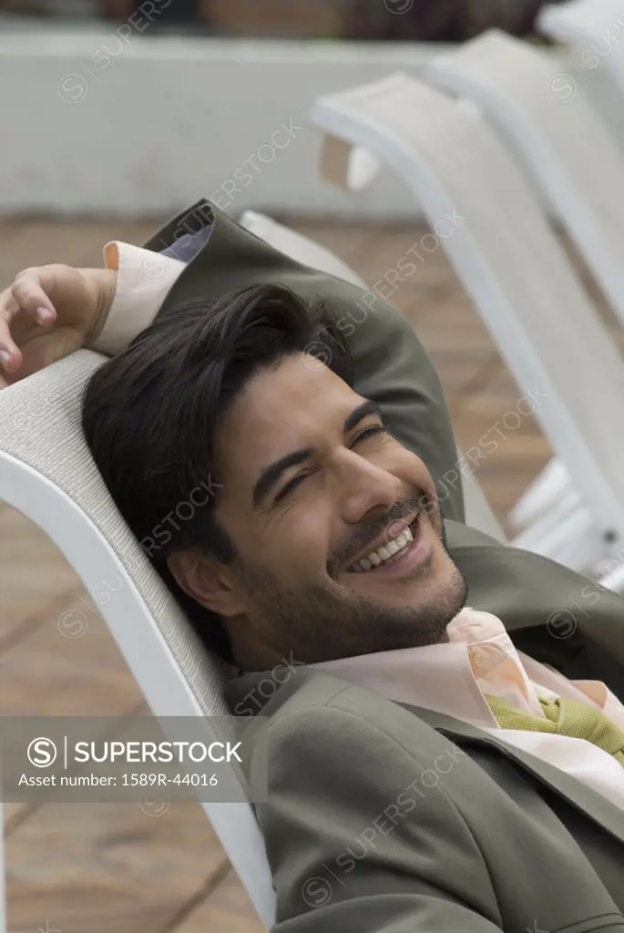 Hispanic businessman sitting in lounge chair